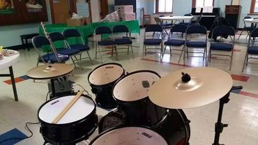 a drum set in front of an empty class 