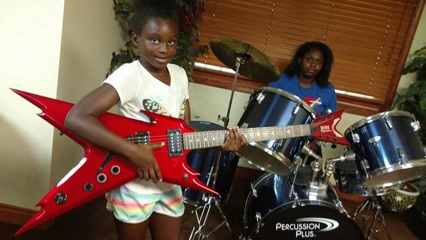 A couple of girls are playing with some music instruments 