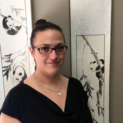 Dr. Christianne Parrot standing in front of panda wall hangings in her clinic.