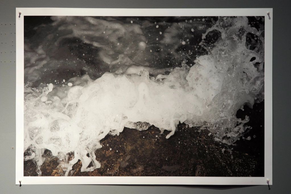 Black and white photo of ocean waves crashing against rocks.
