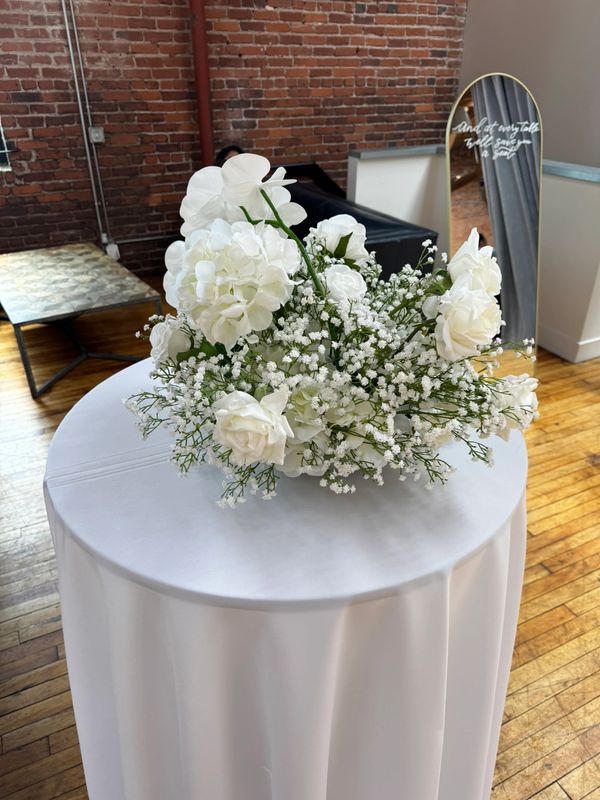 Elegant white floral centerpiece on a round table.