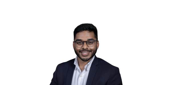 Male smiling, helpful, wearing a suit.