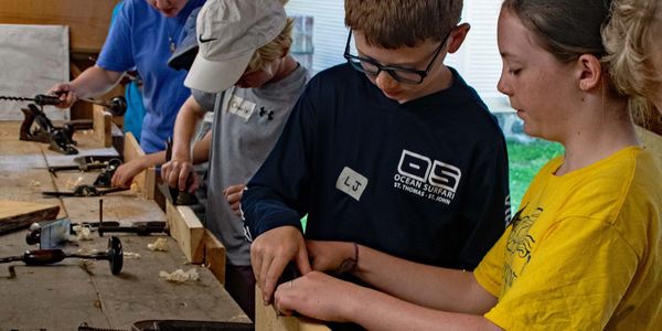 The Boatshop campers using traditional hand tools. 