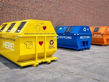 Color-coded recycling bins for textiles, general recycling, and plastics/paper.
