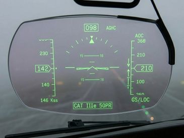 Heads-up display showing aircraft flight data and navigation information.