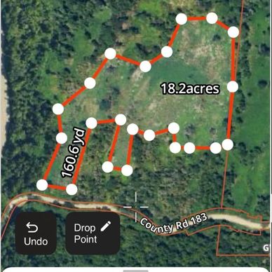 Aerial view showing a marked 18.2-acre land plot with measurement points along its boundary.