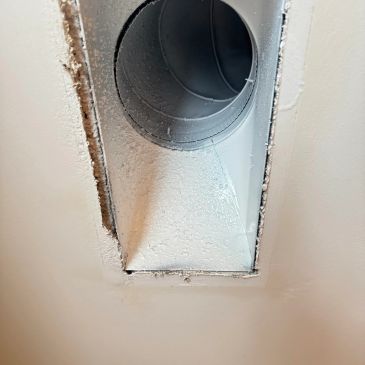 Dusty metal vent duct inside a drywall ceiling.