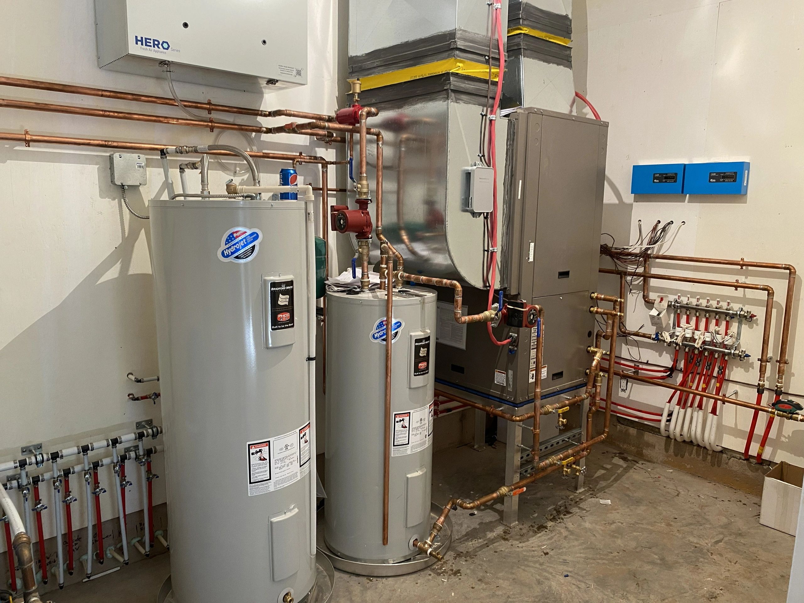 Utility room with water heaters, HVAC system, and copper piping.
