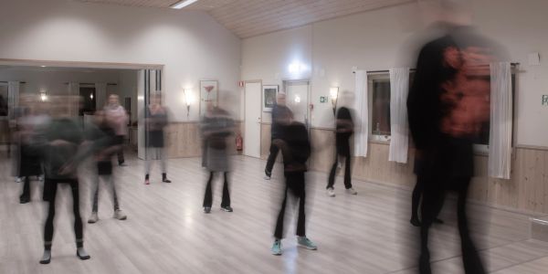 Slørete mennesker som står i et rom.