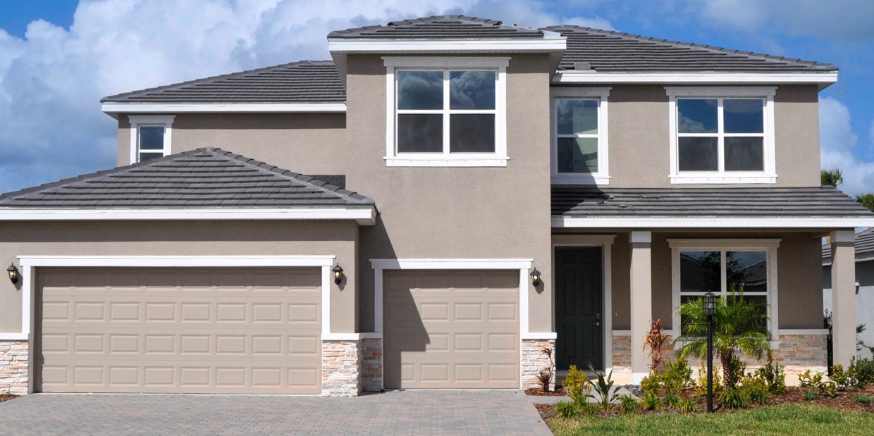 Modern two-story house with beige exterior and three garage doors.