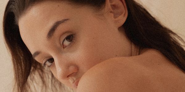 Close-up portrait of a woman looking over her shoulder with natural lighting.