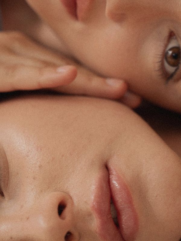 Close-up of two faces showing natural skin texture and features.