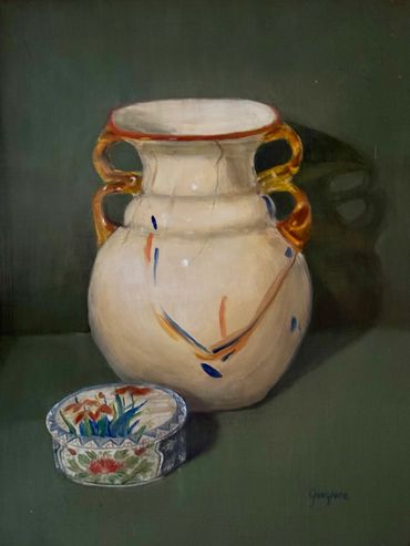 ivory blown glass vase with clear orange handles, in front is a round ceramic bowl with lid