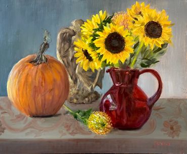 Pumpkin, red glass vase filled with sunflowers