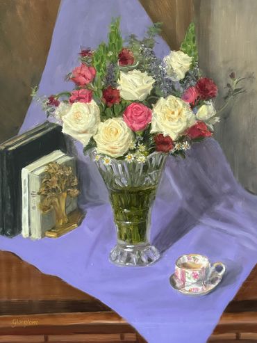 White and pink roses in crystal vase, lavender cloth, tea cup, books