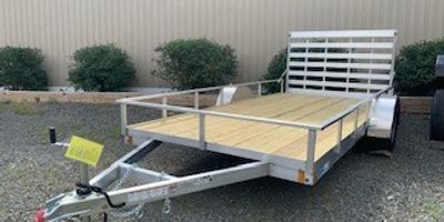 Flatbed utility trailer with wooden deck and metal frame.