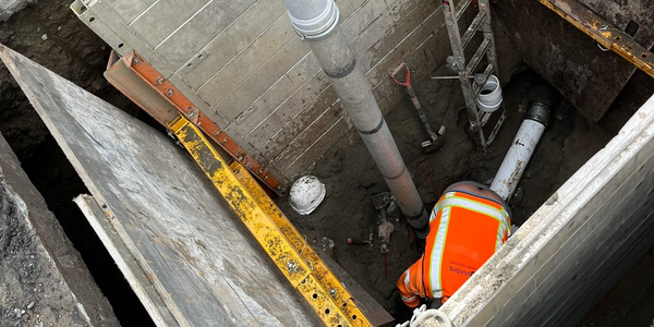 worker in hole jet cleaning a clogged sewer drain on an emergency service