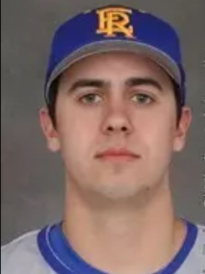 Young baseball player wearing a blue cap and jersey.