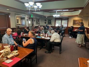Group of people gathered in a restaurant for a meeting.