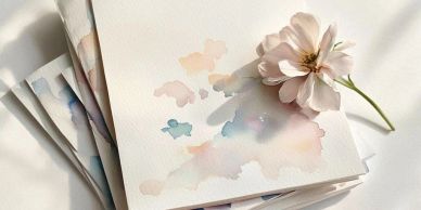 A flower resting on watercolor paper with pastel paint.