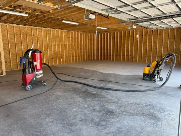 Concrete floor polishing equipment in an unfinished garage.
