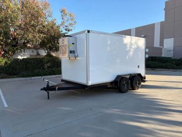 White refrigerated trailer parked outdoors in a parking lot.