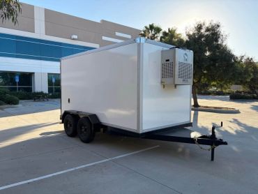 White enclosed trailer parked outside a building.