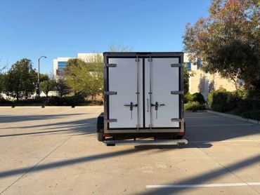 Rear view of a white box truck parked outdoors.