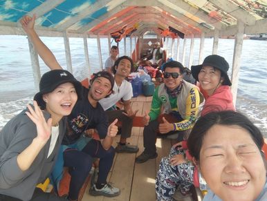 Grupo sonriente en un bote cubierto en el agua.