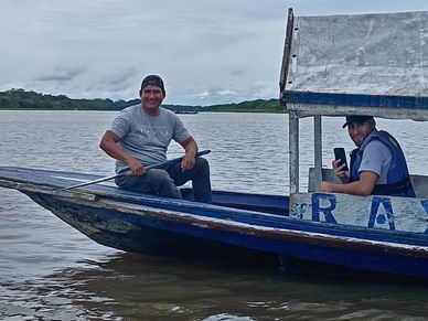 Dos hombres en un bote azul en el agua.
