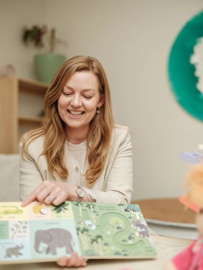Woman happily reading a children's book.