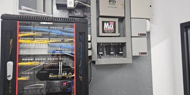 Server rack with network cables and control panels on the wall.
