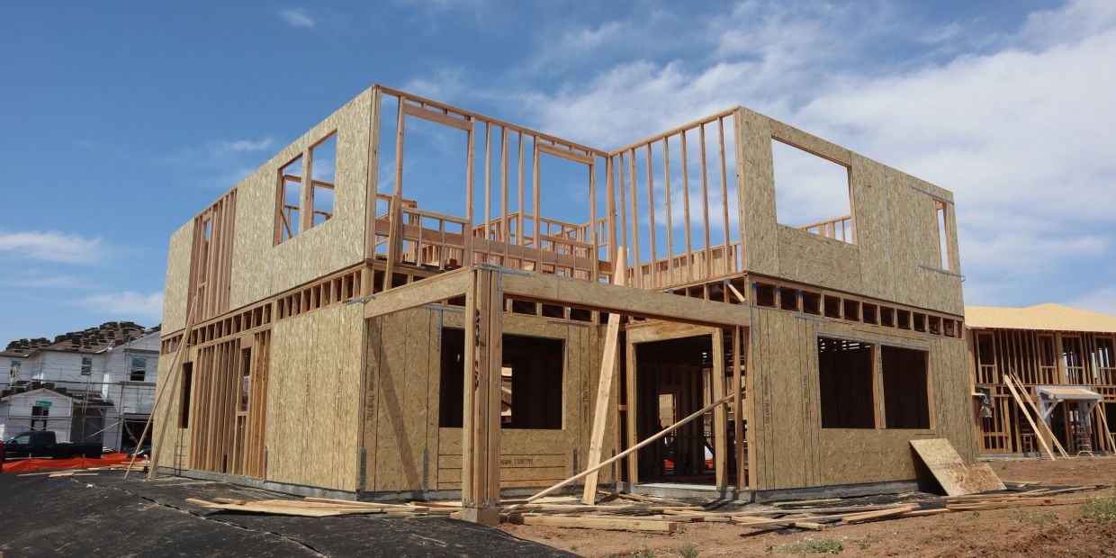 Wooden frame of a two-story house under construction.