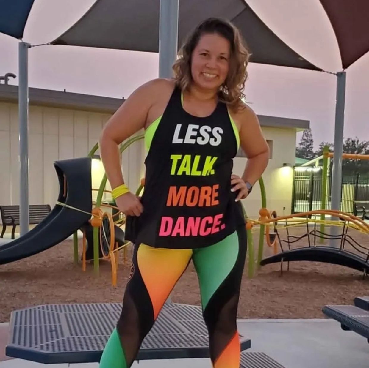 Woman in colorful workout clothes with a motivational dance message.