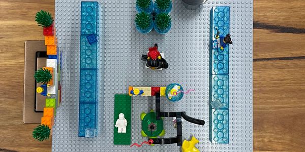 Top view of LEGO scene with minifigures and transparent blue blocks.
