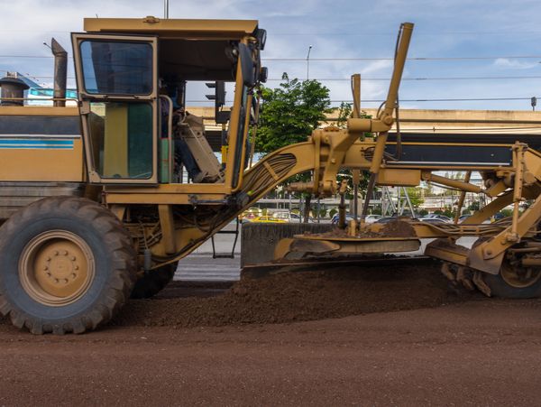 Motorgrader working at Construction site of sky train is a big infrastructure for transportation