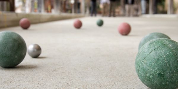 Several bocce balls arranged on a bocce court.