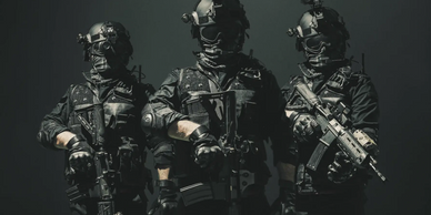 Three fully armed and masked tactical operators stand ready in dark gear.