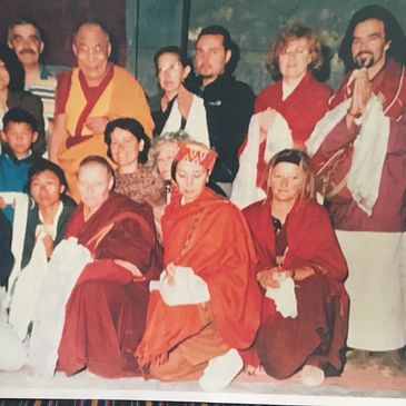Group photo of people in traditional robes and casual attire.