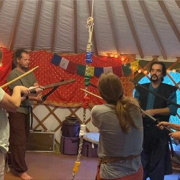 Group practicing sword fighting in a decorated room.