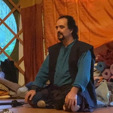Man meditating indoors in a peaceful setting.