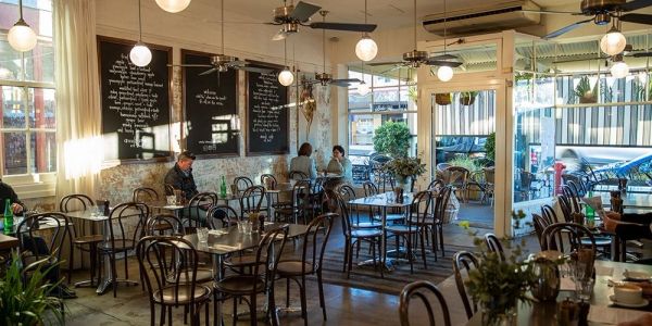 Cozy cafe interior with round tables and wooden chairs.