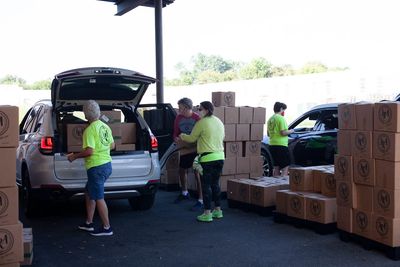 Volunteer load boxes into vehicle