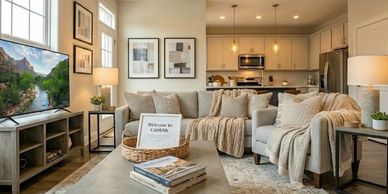 Durable area rug, neutral throw pillows textured blankets, warm lighting, coffee table books.