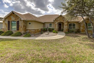 Single-story house with stone accents and a curved walkway.
