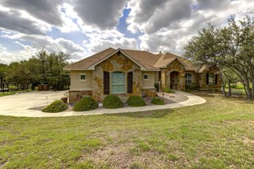 Single-story house with stone accents under a cloudy sky.