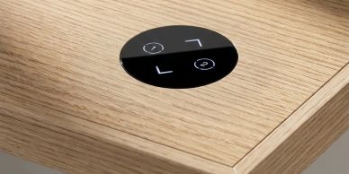 Close-up of a circular touch control on a wooden surface.