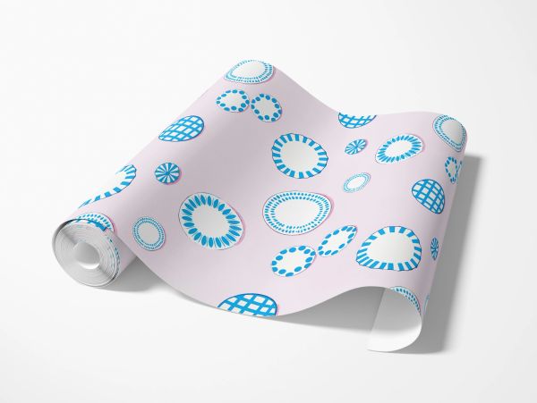 Rolled wallpaper with blue circular patterns on light pink background.
