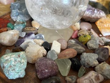 A collection of various colorful crystals and stones on a wooden surface.