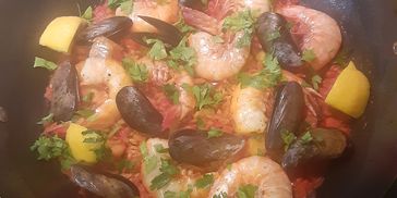 Seafood paella with shrimp, mussels, lemon, and parsley.